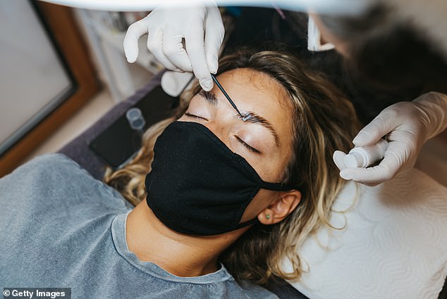 The process neutralizes the hair bond and allows the brow artist to reshape it using Saran Wrap to keep the hairs in place (stock image)