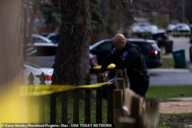 .  A police officer rolls out a crime scene tape.  A suspect is in custody and will be interrogated on Wednesday afternoon