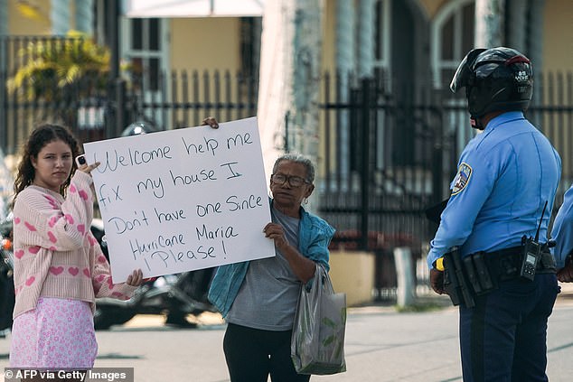 A demonstrator holds a sign during a protest against US Vice President Kamala Harris' visit to San Juan, Puerto Rico