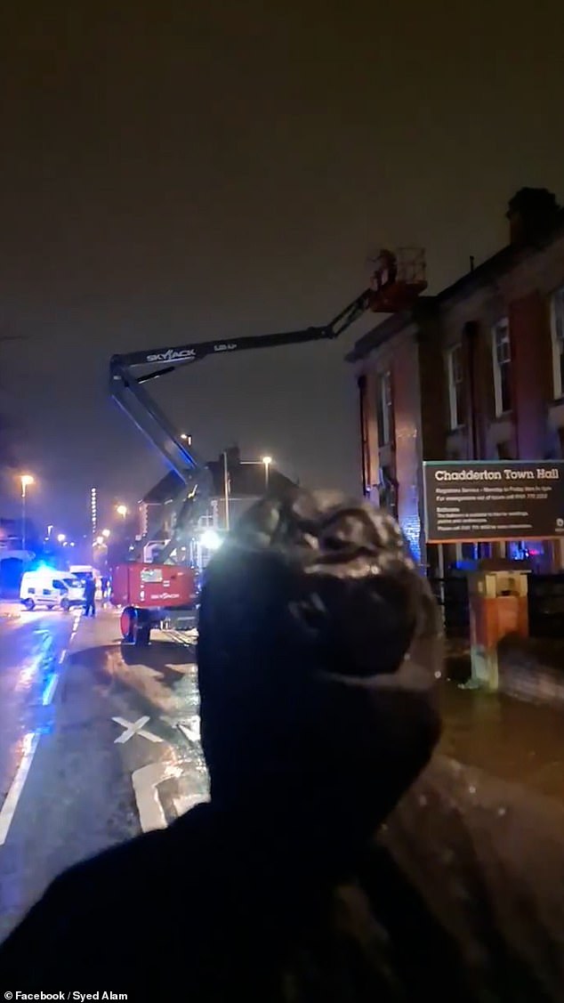 There were two people standing on the platform that was raised to full height above the roof of the building