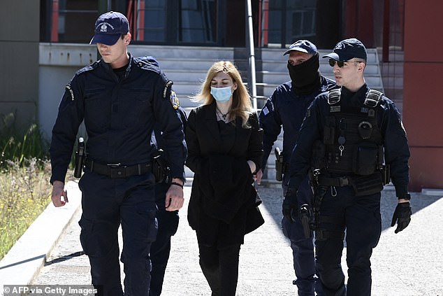 Police officers escort to court Roula Pispirigou (C), a 35-year-old woman prosecuted for killing her three daughters in three years, in Athens on March 29, 2024