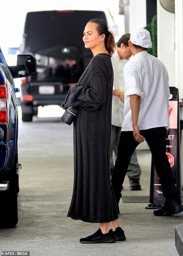 Teigen's dark hair was styled in a low ponytail and she appeared makeup-free