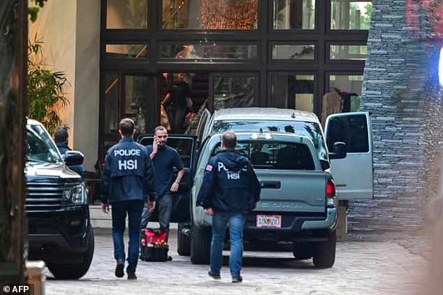 Homeland Security Investigation agents are seen at the entrance of American producer and musician Sean "Diddy" Combs' home on Star Island in Miami Beach on March 25, 2024