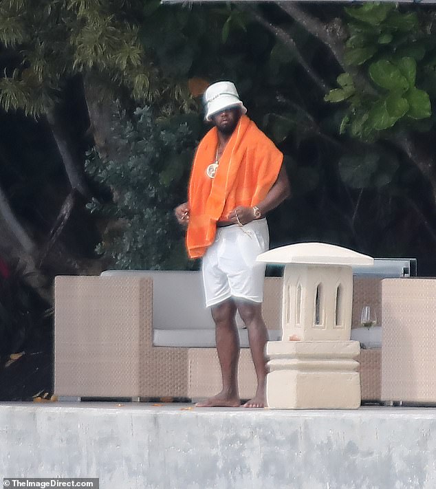 At one point, the embattled rapper reappeared wearing a matching white hat, a huge gold chain, watch and bracelet and an orange towel around his shoulders.