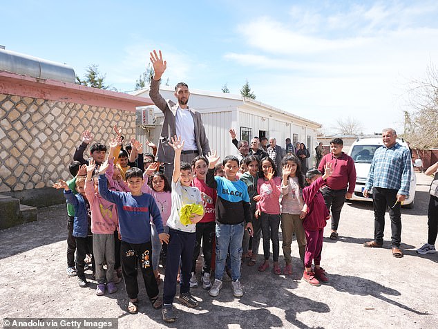 Sultan Kosen, who with his height of 2 meters and 51 centimeters bears the title of 'tallest man in the world', poses for a photo with children