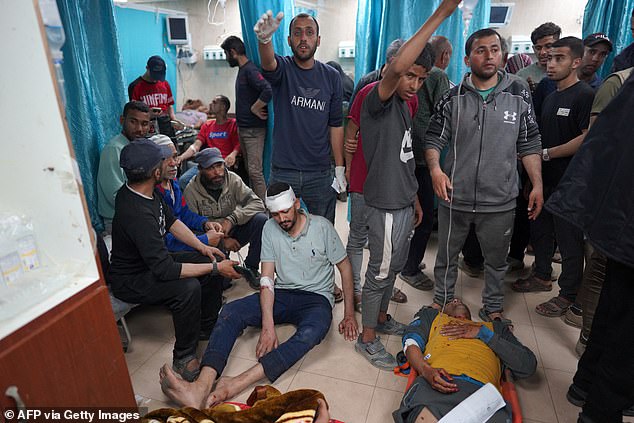 Wounded Palestinian men lie on the ground at Al-Aqsa Martyrs Hospital in Deir al-Balah in the central Gaza Strip, after the Israeli bombardment on March 31