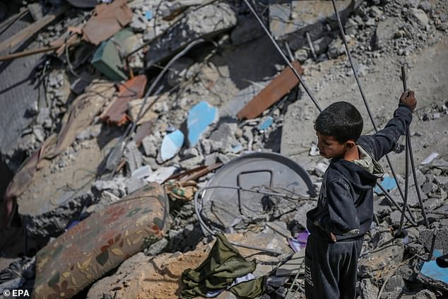 A Palestinian boy inspects his destroyed family home after an Israeli airstrike in the Al Maghazi refugee camp, southern Gaza Strip, on March 31