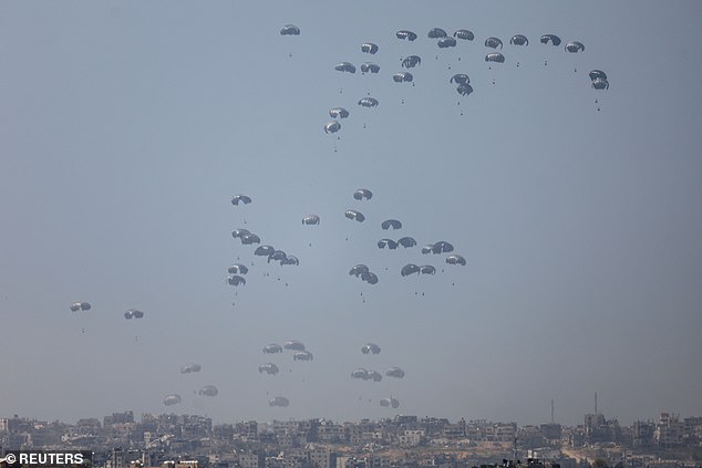 Humanitarian aid falls through the air towards the Gaza Strip after being dropped from a plane on March 31