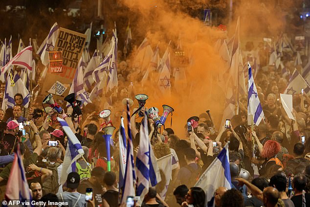 Protesters hold up Israeli flags and light smoke flares as they demand the release of hostages held by Hamas