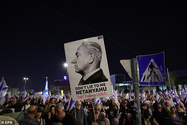 An anti-government protester holds up a sign that reads 