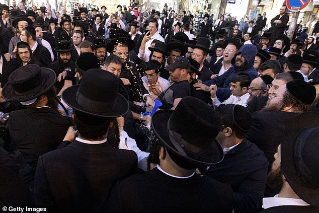 Pictured: Protesters clash with ultra-Orthodox men in Jerusalem's Meha Sha'arim neighborhood on Sunday