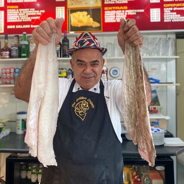 Chris Kanizi, 65, holds up fish in his award-winning restaurant in south-east London