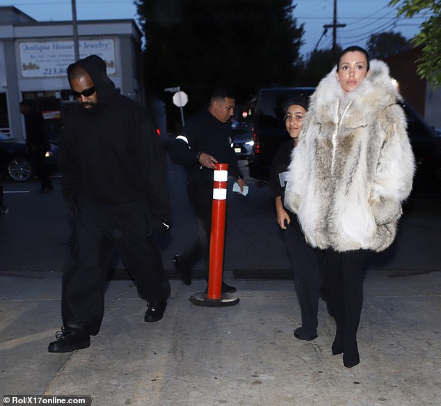 Bianca Censori, 29, ditched her recent racy look and wore a heavy coat as she headed out for dinner on Saturday with stepdaughter, North West, 10, and husband Kanye West, 46,