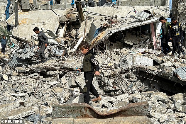 A Palestinian boy walks at the site of an Israeli attack, amid the ongoing conflict between Israel and the Palestinian Islamist group Hamas, in Rafah