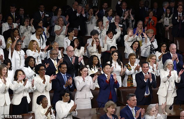 Democratic members of Congress cheer on President Joe Biden during State of the Union address – many Democratic female lawmakers wore white to show their support for reproductive rights