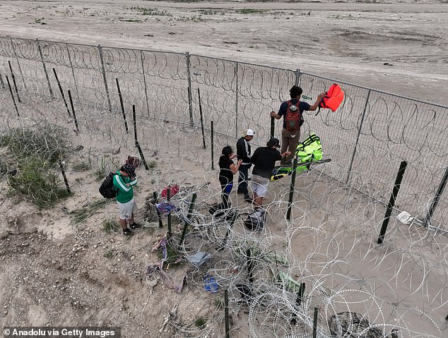 Migrants cross the border at Eagle Pass from Mexico.  Both Biden and Trump headed to the southern border for dueling events on Thursday as polls show immigration is a major issue among swing state voters.