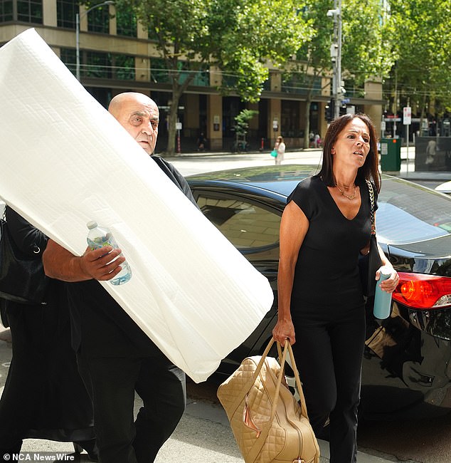 Aggie Di Mauro and Celeste's father Tony enter the Supreme Court of Victoria on Thursday with their daughter's ashes under a white blanket