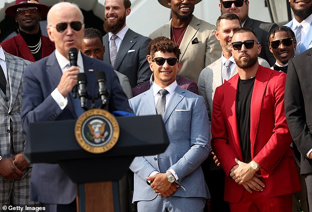 Butker can be seen standing over Biden's left shoulder, wearing a pro-life tie with his gray suit jacket