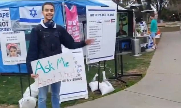 He was seen on footage standing in front of Stanford's Blue and White Tent, an Israel education tent staffed by Jewish students, holding a sign that read, 