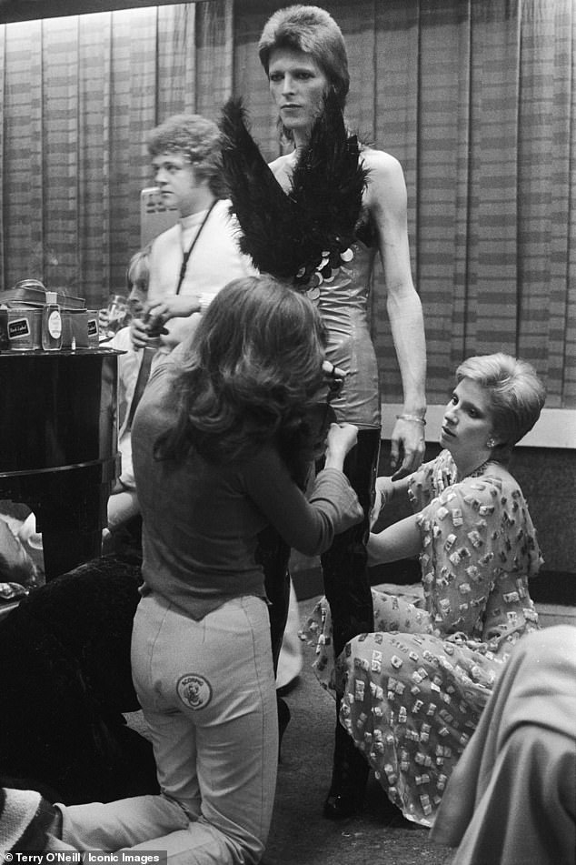 Bowie being dressed by Angie Bowie and Suzi Ronson in 1973. Bowie performed as Ziggy Stardust for the last time at the Marquee club during a three-night filming session of 'The 1980 Floor Show'