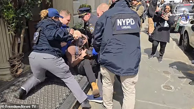 NYPD officers detained a protester Saturday afternoon as the crowd shouted 