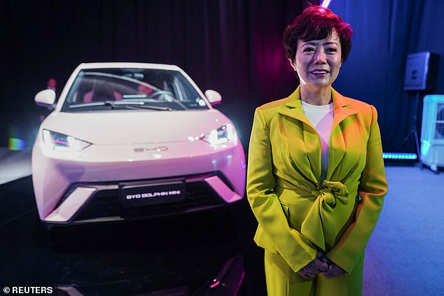 The photo shows Stella Li, president of BYD Americas, with a BYD Dolphin electric vehicle