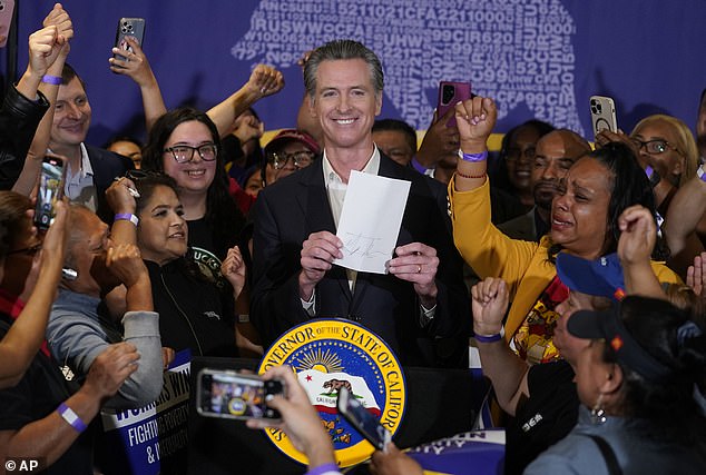 California Governor Gavin Newsom signs the fast food bill surrounded by fast food workers at SEIU Local 721 in Los Angeles on September 28, 2023