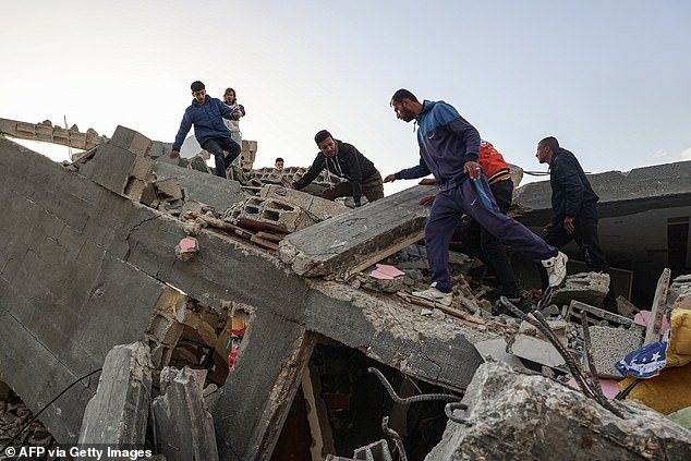 Palestinian men search for salvageable items amid the rubble of a house destroyed in an overnight Israeli airstrike in Rafah in the southern Gaza Strip on March 3