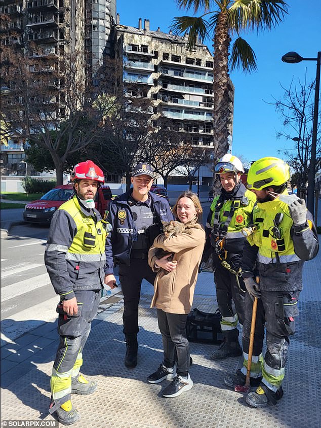 Andrea Rubio and Coco with the firefighters.  Mystery still surrounds Coco's survival of the tragedy that killed ten people and claimed the lives of about a hundred other pets