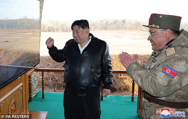 A leather-clad Kim Jong Un (pictured, left) was seen raising his fist in the air as he oversaw a live-fire exercise from a series of 'newly equipped super-sized' rocket launchers