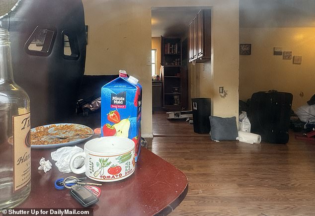 A half-finished meal, an empty vodka bottle and an open juice carton sit on a table in an Amityville, New York, home that was raided Monday in connection with the discovery of two dismembered bodies