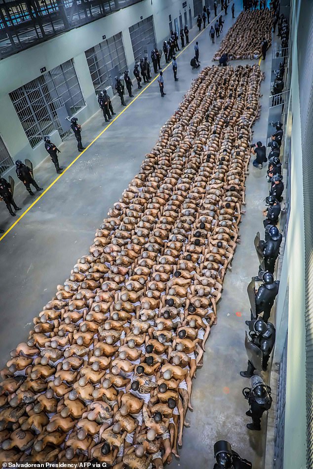 Police officers in riot gear monitor the arrival of prisoners from the MS-13 and 18 gangs to the new prison "Terrorist Detention Center"