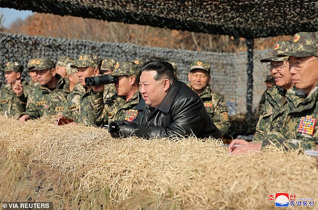 North Korean leader Kim Jong Un (pictured center) looks on as he leads a military demonstration involving tank units