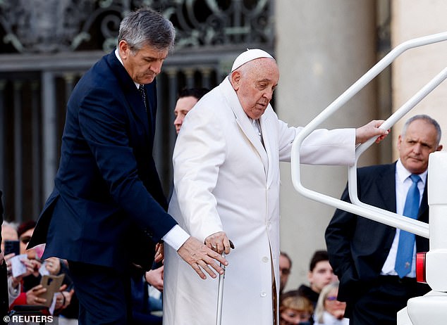The Pope was helped by an assistant as he tried to get into the back of the Popemobile