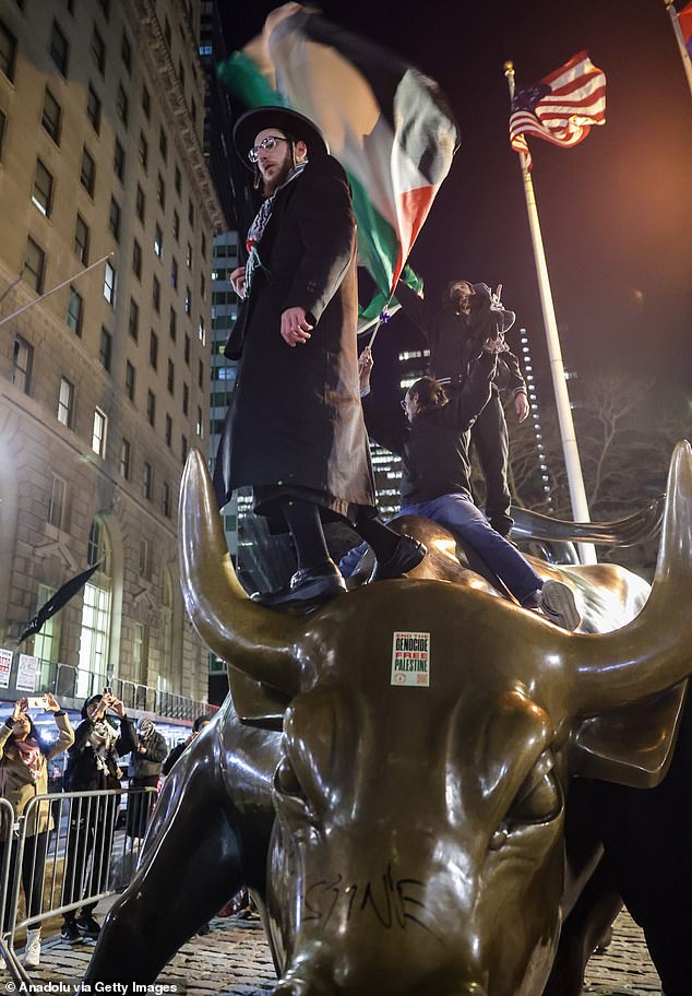 Video footage captured the chaotic scene, as protesters were seen climbing atop the Charging Bull statue and defacing it with the message 