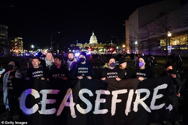 Pro-Palestinian protesters stand in the middle of the street in an attempt to block President Joe Biden's motorcade between the White House and the Capitol for his State of the Union address on Thursday evening.  Pictured: Jewish Voice for Peace activists join a pro-Palestinian protest on Pennsylvania Ave.  on March 7, 2024