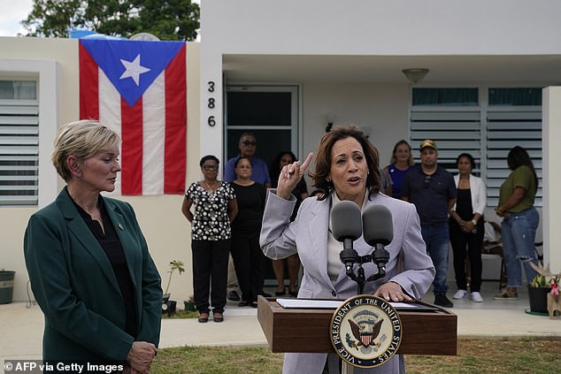 U.S. Secretary of Energy Jennifer Granholm (L) listens as Vice President Kamala Harris speaks during a visit to Canovanas, Puerto Rico,