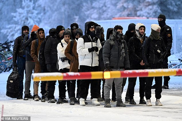 A group of asylum seekers arrive at the border in Salla, Northern Finland, in November 2023, amid a migrant crisis caused by Russia