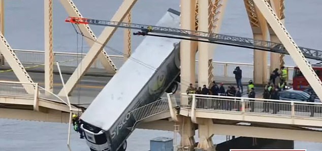 A large truck has crashed off the side of a bridge in Indiana, leaving the driver hanging precariously from the side