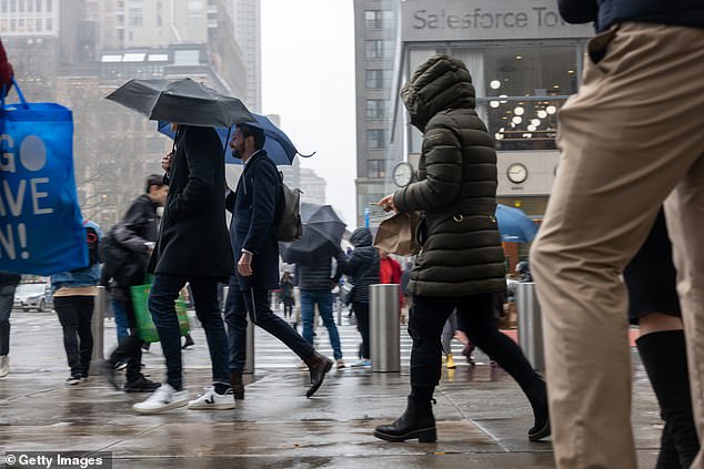 Millions of people in the North East have been warned of flooding as rain is forecast to lash the region for 24 hours.  Pictured: People walking through the rain in New York City