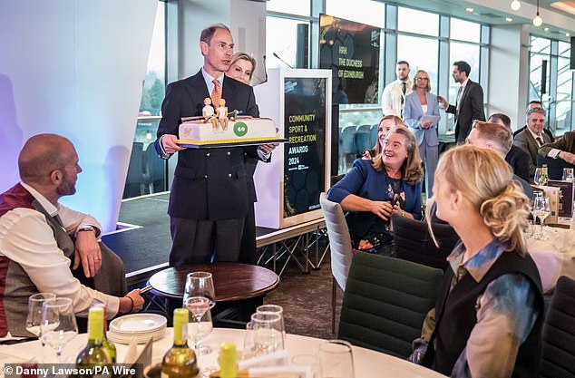 The Duke of Edinburgh looked delighted as he carried his giant 60th birthday cake