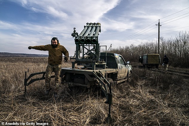 Ukrainian soldiers prepare to fire rockets from a Grad PC3B, using a homemade shuttle