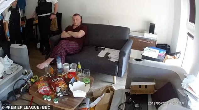 Mark Gould, pictured, is seen in May 2018 sitting in his pajama bottoms, surrounded by crisp packets, bongs and cardboard boxes, as investigators search his south London home.  He was jailed for 11 years for operating an illegal streaming service worth £7 million