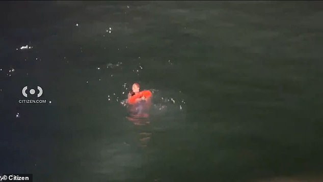 The woman was seen paddling in the water as a Los Angeles County Sheriff's boat attempted to rescue her by tossing a floating donut into the ocean, which she grabbed and then lifted onto the boat.