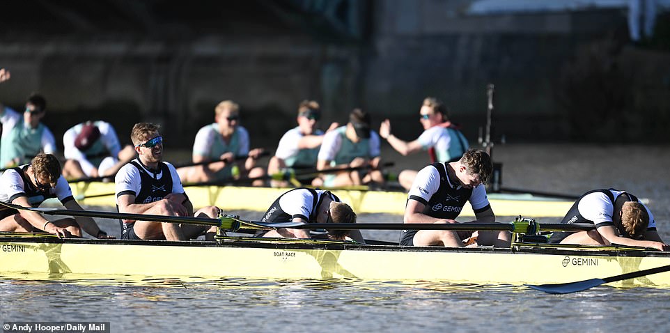 The dejected Oxford crew slumped forward in their boats as Cambridge toasted their achievement in the background