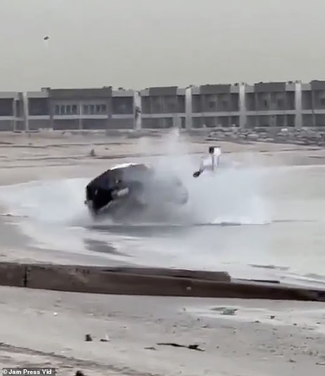 You see the driver fly out of his car as it crashes into the sand and rolls into the water