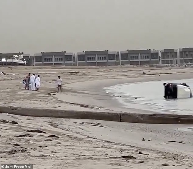 Amazed beachgoers run over to watch him, gathering around him as the man sits down on the sand