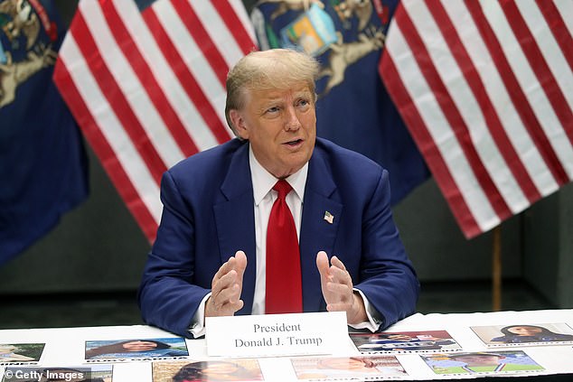 Trump speaks at a table full of images of victims killed in the country illegally by immigrants.  The images were printed and distributed for the event in Grand Rapids, MI