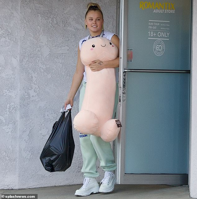 The star - who recently ditched her good-girl image - emerged with a large shopping bag and a phallic plushie