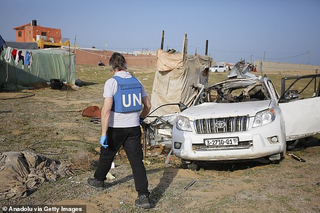 An official inspects the damage to an aid convoy vehicle in Deir Al-Balah, Gaza